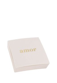 Kvadratisk krämfärgad låda med en slät yta och guldskrift som stavar "amor" på toppen, med subtilt rundade kanter.