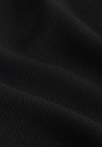 Črna tkanina z teksturirano površino, ki ima fine navpične rebraste vzorce, poudarjajoč njen gladek sijaj in subtilen vzorec. Mehko in prožno blago.