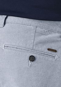 Light gray woven fabric pants featuring a buttoned pocket, contrast stitching, and a small metal brand tag on the side.