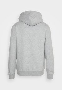 Sudadera gris con un tejido suave y texturizado. Presenta capucha y puños acanalados, diseño simple, sin logotipos ni patrones visibles.