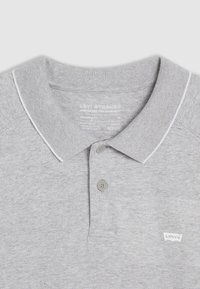 Sivé polo tričko s golierom, ktorý sa dá sklopiť, tromi gombíkmi a bielymi šitými detailami. Na ľavej strane sa nachádza malé logo Levi's.