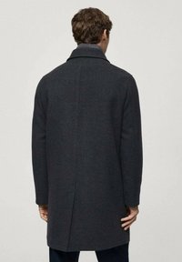 Mørkegrå uldfrakke med klapkrave, lange ærmer og lige snit, med en glat tekstur og minimal detaljer på ryggen.
