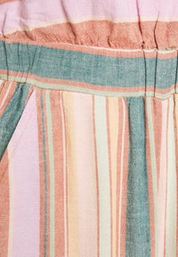 Tela a rayas multicolor con tonos pastel de rosa, naranja y azul verdoso, con una textura suave y un detalle de cintura fruncida.