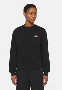 Felpa nera in cotone con colletto a coste, maniche lunghe e un piccolo logo multicolore sul petto. Presenta una vestibilità rilassata e dettagli sulle cuciture laterali.