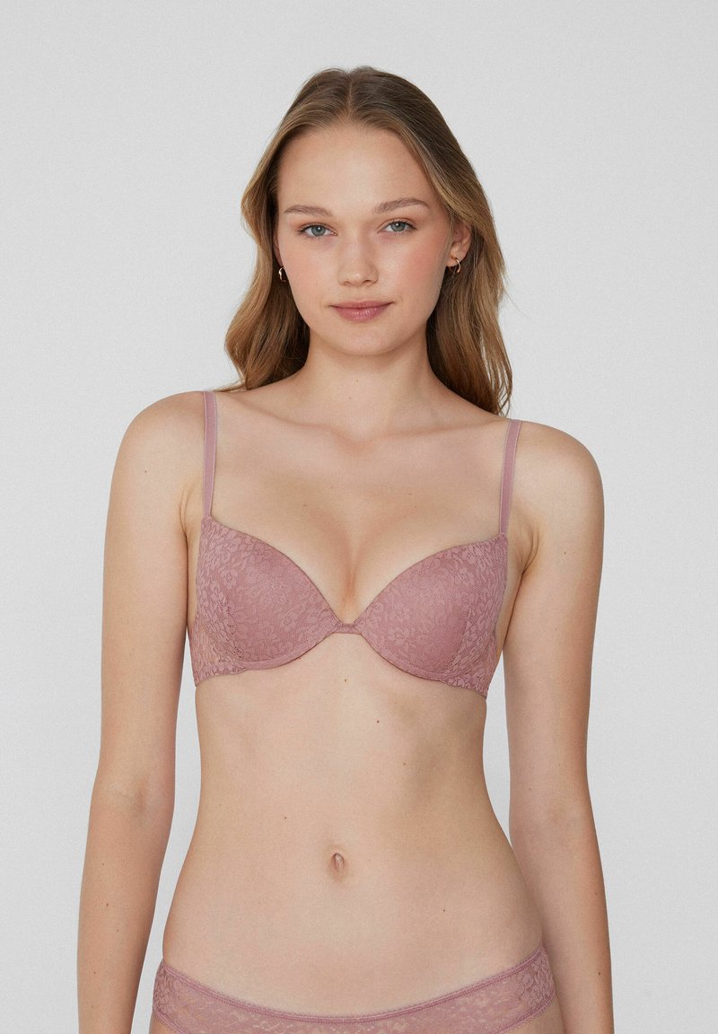 Kanten bralette in stofroze met verstelbare bandjes, gevoerde cups en een soepele textuur. Bloemenpatroon op de stof verhoogt de visuele detail.