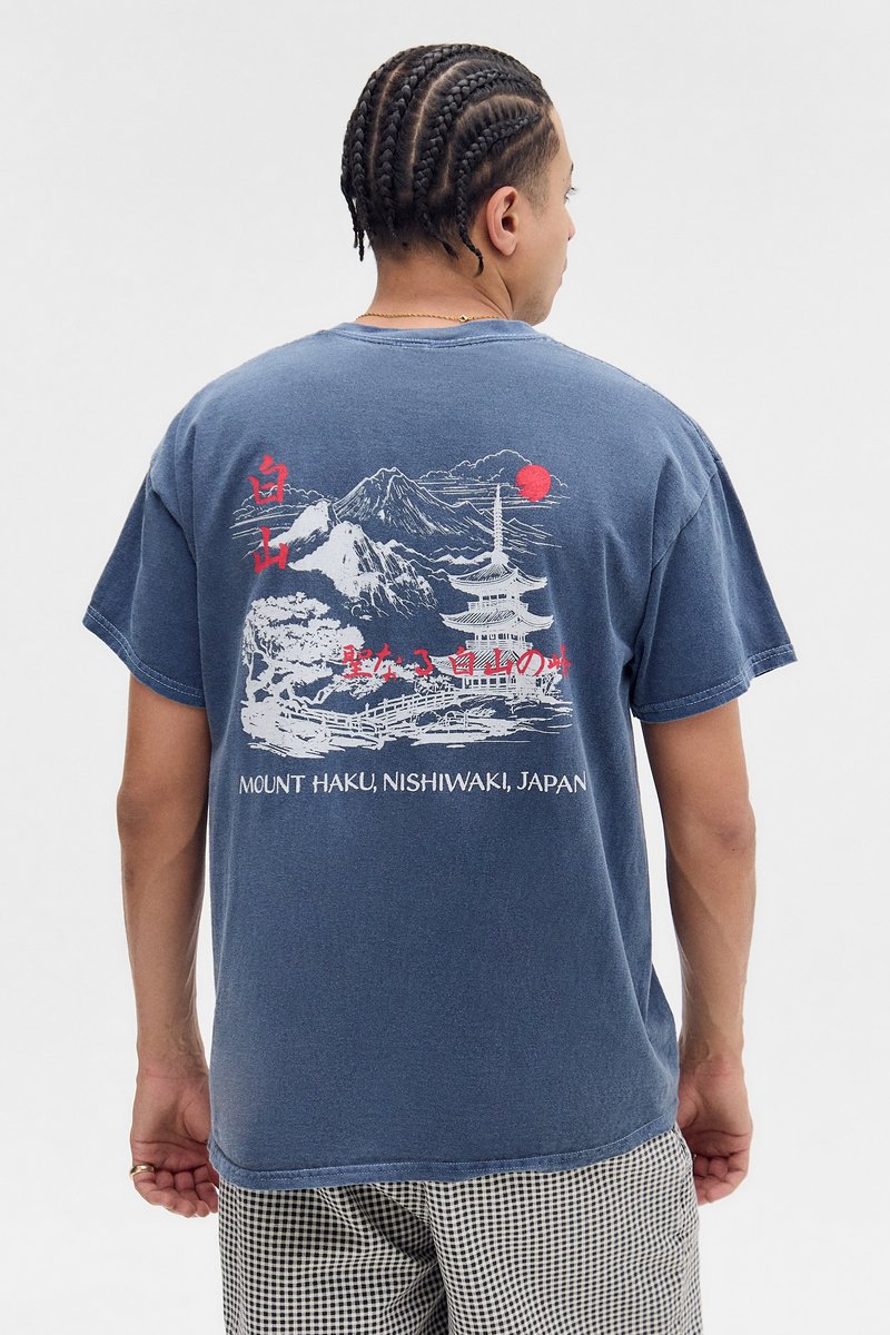 Mørkeblå bomuldst-shirt med et grafisk motiv af bjerge, en pagode og en rød sol på ryggen, med japansk tekst under designet.