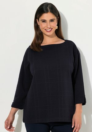 Top blu navy con scollatura quadrata, maniche tre quarti e motivo a griglia testurizzato. Il tessuto sembra morbido con una vestibilità comoda.