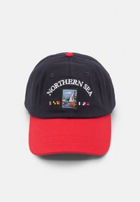 Marineblau und rote Baseballmütze mit gesticktem "NORTHERN SEA"-Text und einem malerischen Aufnäher mit Booten auf dem Wasser und Fahnen. Aus Baumwollmaterial.