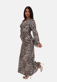 Robe longue à imprimé léopard avec des manches longues, décolleté en V et jupe fluide. Le tissu semble lisse et léger avec un éclat subtil.