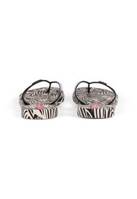 Black thong sandals with a striped zebra pattern on a beige footbed and a pink accent on the strap, showing the rear view.