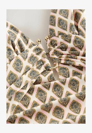 Marmora auduma ar maigu rozā krāsu un zeltītām akcentiem, kurā ir ziedu un ģeometriski raksti. Iekļautas zeltītas detaļas.