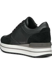 Sneaker nera caratterizzata da una combinazione di pelle liscia e camoscio, una robusta intersuola bianca con accenti grigi e un design a pannelli testurizzati.