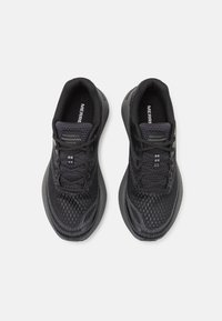 Zapatillas deportivas negras hechas de malla y material sintético. Presentan una textura con patrón y cordones; suela acolchada para mayor comodidad.