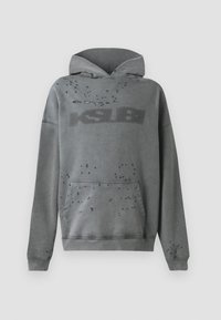 Sivá mikina s kapucňou, predným vreckom, s tonálnym logom a rozptýleným opotrebovaním. Mäkká tkanina s voľným strihom a kapucňou so šnúrkou.