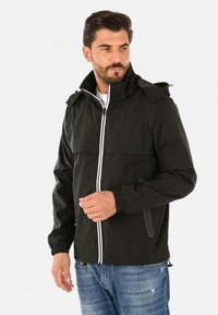 Giacca leggera nera con colletto alto, zip bianca e polsini elasticizzati. Presenta un design bicolor e tasche laterali discrete.