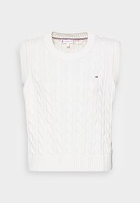 Vit ärmlös stickad tröja med kabelmönster och ribbad halsringning och nederkant. Liten logotypdetalj i kontrasterande färger på framsidan.