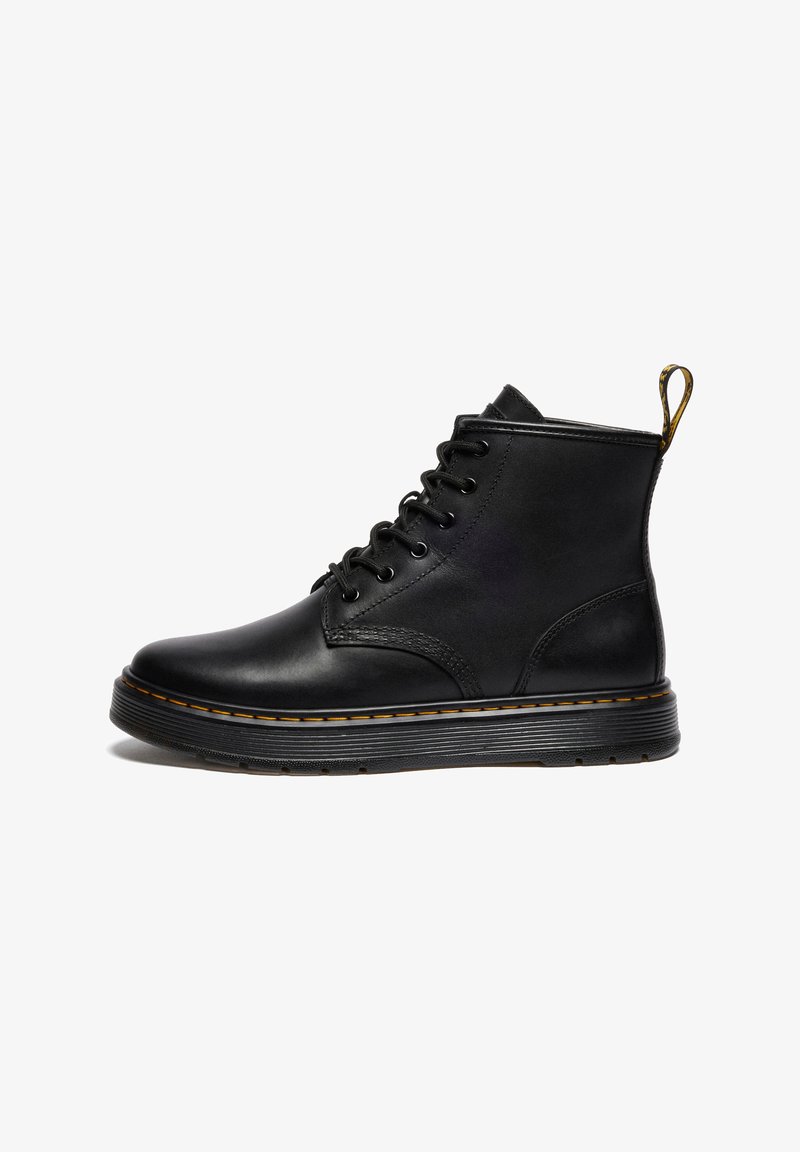 Juodas odinis raištelių ankle boot su storu nelygiu padu ir geltonais siūlų akcentais, nugarinėje pusėje yra kilpa.