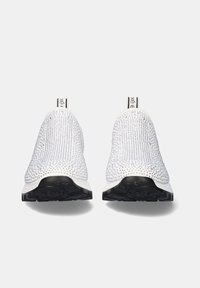 Zapatos blancos sin cordones con parte superior texturizada, que cuentan con una suela de goma negra y un bucle en el talón de contraste para facilitar su uso.