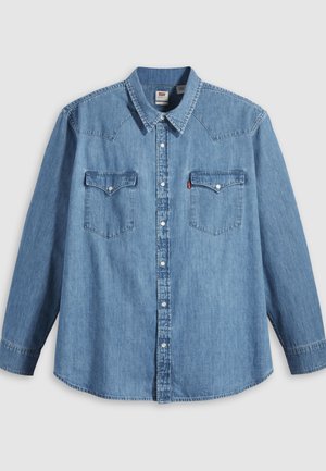 Hele sinine teksapikk varrukaga särk terava kraega, kahe rinnatasku ja valgete trukikinnitustega. Omab kaardus ääre ja lääne stiilis õlapaneeli.