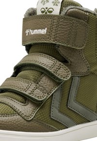 Scarpe alte verdi con pelle e tessuto testurizzati, dotate di due cinturini in velcro, logo bianco e dettagli a zigzag.