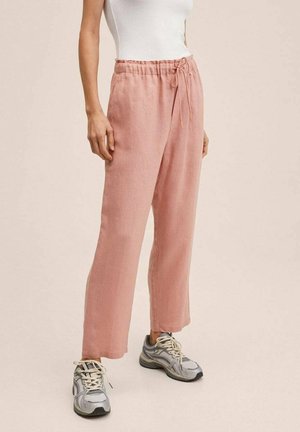 Lichtroze linnen broeken met een relaxte pasvorm, elastische tailleband en verstelbaar trekkoord. Gecombineerd met grijze sneakers.