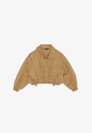 Beżowa kurtka cropped z zamkiem, falbanami z przodu i elastycznymi mankietami. Kołnierz jest szeroki, co dodaje stylowego akcentu do projektu.