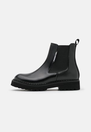 Blankt sort læderankelstøvle med elastisk sidepanel, trækflig bagpå, tyk sål og "Karl Lagerfeld"-mærkat på siden.