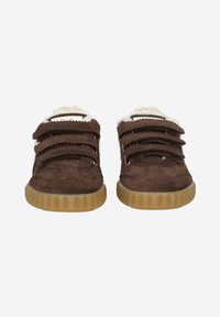 Chaussures en daim marron avec trois bandes velcro, doublure crème et semelle en caoutchouc texturée. Forme arrondie avec des détails de couture subtils.