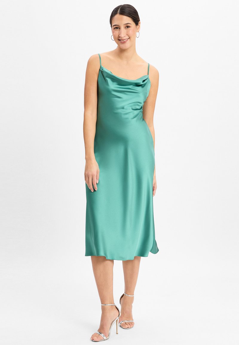 Robe en satin vert émeraude avec un décolleté drapé et des fines bretelles, forme fluide et détail de fente sur l'ourlet.