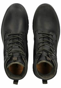Botas de tobillo de cuero negro con laterales texturizados, punteras reforzadas, cordones verde oliva y tiradores. El interior cuenta con un forro marrón.