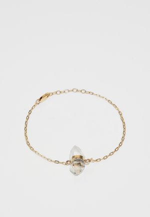 Kuldne käevõru, millel on selge, ebaregulaarses vormis kristallripats, kinnitatud kuldse riba abil, neutraalse tausta vastu.