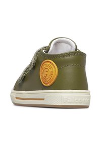 Sneaker in pelle verde oliva con rivestimento interno bianco, suola in gomma e un logo arancione rotondo sul lato. Presenta dettagli di cuciture testurizzate.