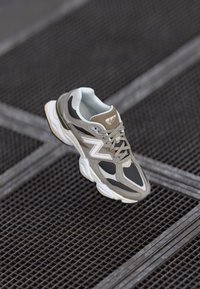 Sneaker med lagdelt design i beige, grå og hvit. Har en dempet såle, snørebånd og logo-detaler. Laget av mesh og syntetiske materialer.