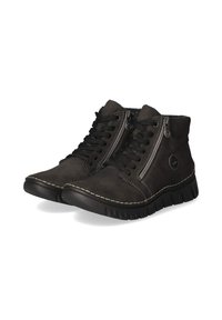 Bottines noires à lacets avec fermetures éclair latérales, semelles épaisses et coutures blanches visibles autour de la base, présentées sur un fond blanc.