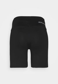 Shorts de sport noirs avec une texture lisse, une taille large et un logo à l'arrière. Coupés au milieu de la cuisse sans motifs supplémentaires.