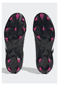 Schwarze Sportschuhe mit einer strukturierten, geformten Laufsohle; ausgestattet mit pinken Traktionsstollen für besseren Grip; elegantes Design mit weißen Akzenten.