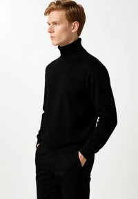 Schwarzer Rollkragenpullover aus glattem Strickstoff. Figurbetontes Design mit gerippten Bündchen und Saum, mit einem hohen Kragen für zusätzliche Wärme.