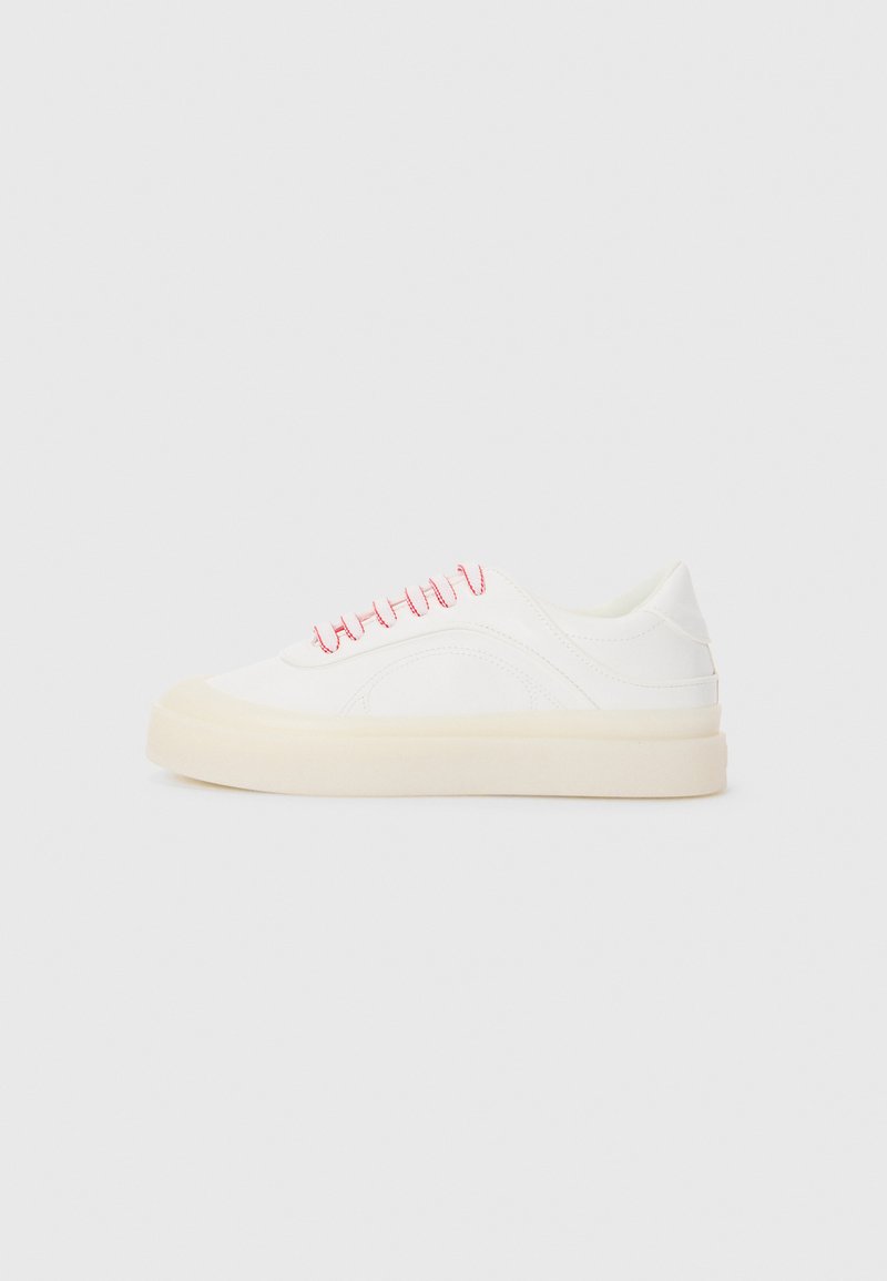 Hvite sneakers med rosa snører, med et glatt skinn-design, rund tå, og en beige gummisåle, inkludert sømdetaljer.