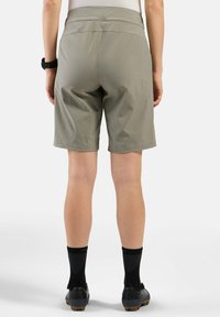 Lichte, kaki shorts met een middelhoge tailleband die net boven de knie uitkomen, met een gladde textuur en zonder zichtbare patronen.