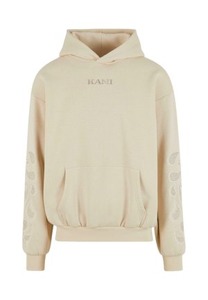 Béžová mikina s klokanní kapsou, vyšitým logem „KANI“ na hrudníku a akcenty s paisley vzorem na rukávech. Měkká textura látky.
