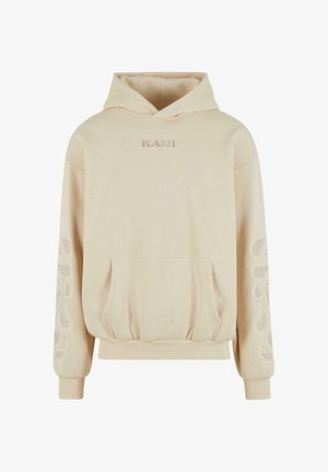 Béžová mikina s klokanní kapsou, vyšitým logem „KANI“ na hrudníku a akcenty s paisley vzorem na rukávech. Měkká textura látky.