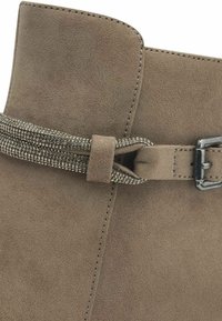 Bottine en daim brun avec une finition texturée, présentant un détail de ceinture métallique décorative et une boucle en argent sur le côté.