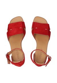 Rode suède sandalen met een platte zool, open teen, enkelband en uitsnijdingen. Beschikt over een gladde tan binnenzool met logo-detail.