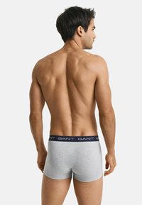 Šedé bavlněné boxerky s námořnickým pasem, který nese bílé písmo "GANT". Navrženy pro pohodlí a těsné padnutí.