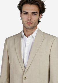 Beige Sakko mit einer Zwei-Knopf-Verschluss, Reverskragen und einer einzelnen Brusttasche, kombiniert mit einem weißen Hemd. Glatte Textur.