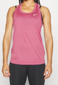 Rosa atletisk linne gjort av mjukt, andningsbart tyg med rundad halsringning och en liten vit Nike-logotyp på övre vänstra sida.