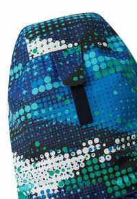 Blau- und grün gemusteter Stoff mit variierenden Punktgrößen, die in ein dynamisches Design integriert sind. Enthält einen dunkelblauen Riemen für die Funktionalität.