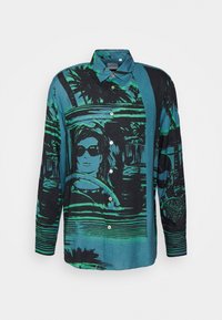 Multicolore blouse met knopen die een grafische print van een vrouw in een zonnebril, palmbomen en abstracte patronen in blauw en groentinten toont.