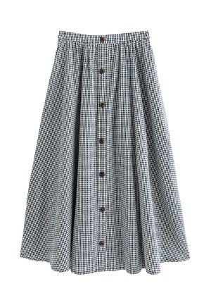 Czarna i biała spódnica midi w kratę gingham o rozkloszowanym kroju, z zapięciem z przodu na siedem brązowych guzików.