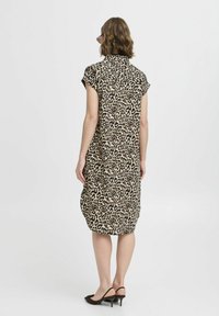 Abito con stampa leopardata dal fit rilassato, maniche corte a cappuccio e colletto, realizzato in un tessuto leggero e con orlo curvato.